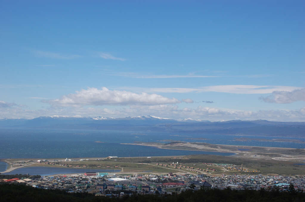 An overview of Ushuaia with ocean and then mountains behind it.