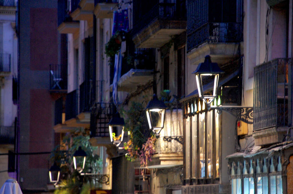 A row of lit lanterns against a building at night.