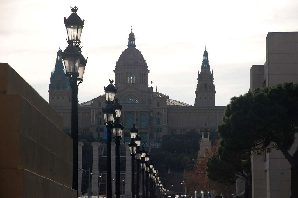 A large palace at the top of a long flight of stairs with a row of lamposts in the foreground.