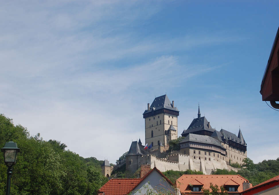 A large castle on a hill above a small town.