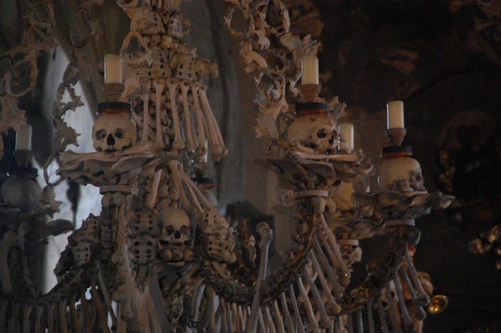 A chandelier made of human bones with candles resting on skulls.