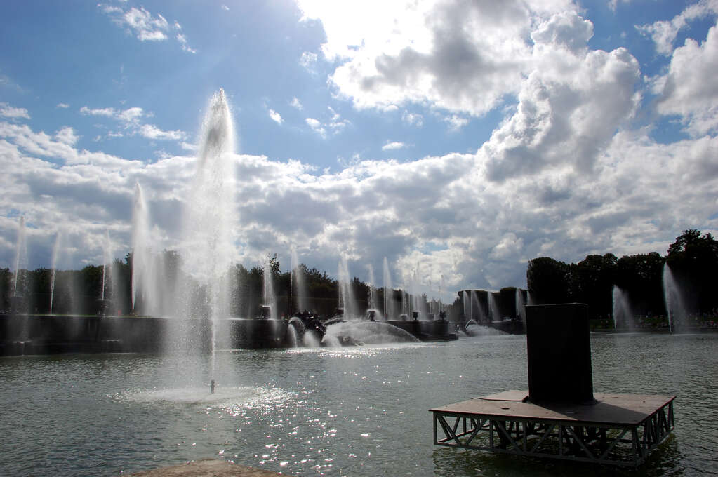 A series of synchronized fountains spraying water over a pond.