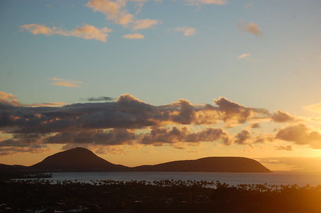 Mountains in the distance past the ocean during sunrise.