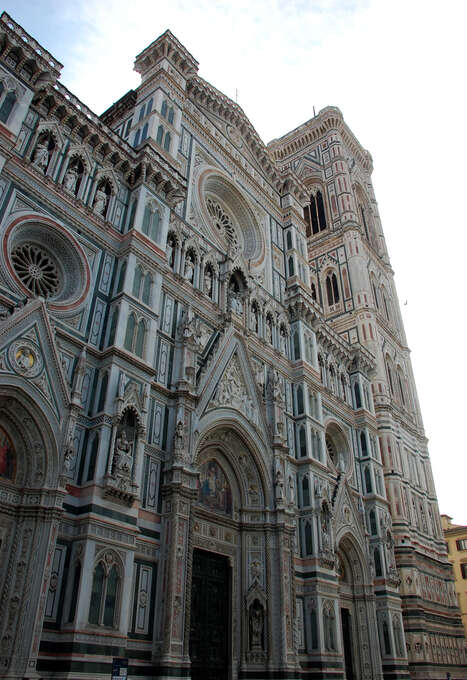 A cathedral and bell tower with ornate white, pink, and green marble façades.