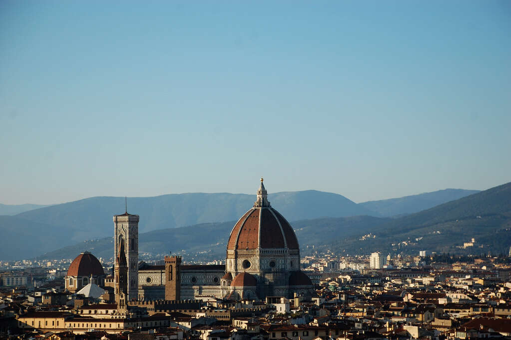 An overview of a city with a giant domed cathedral rising above the surrounding buildings..