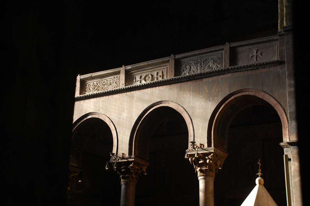 Light being cast onto archways with very dark shadows behind.