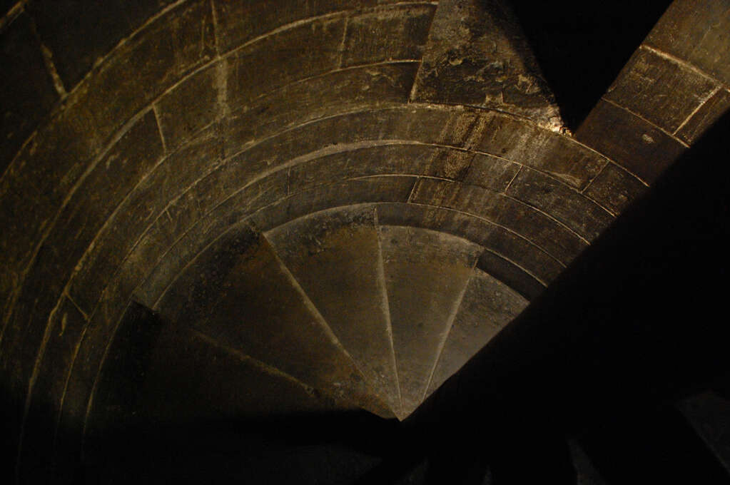 A narrow descending spiral staircase.