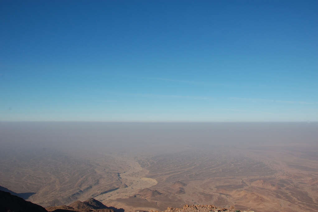 A view of the desert from very high up that extends to the horizon.