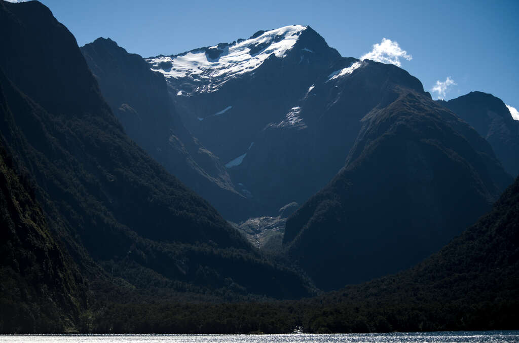 A tall, snow-covered mountain rising above a lake.
