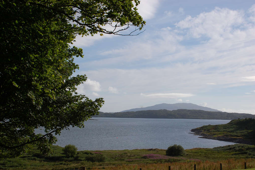 A lake surrounded by mild grassy hills.